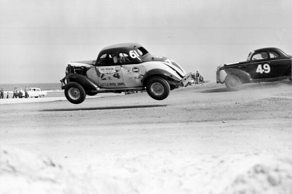 FILE - Red Farmer (61) goes airborne after hitting a hole on the four-mile Daytona Beach road course during the 100-mile Modified and Sportsmen type stock car race in Daytona Beach, Fla., Feb. 14, 1953. NASCAR marks its 75th year in 2023, recalling both its highs and lows. (AP Photo/James P. Kerlin, File)