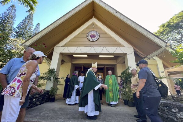 Most Rev. Clarence "Larry" Silva, the Bishop of Honolulu, greets parishioners after Mass at Sacred Hearts Mission Church in Kapalua, Hawaii, Sunday, Aug. 13, 2023. Sacred Hearts Mission Church hosted congregants from Maria Lanakila Catholic Church in Lahaina, including several people who lost family members in fires that burned most of the Maui town days earlier. (AP Photo/Haven Daley)