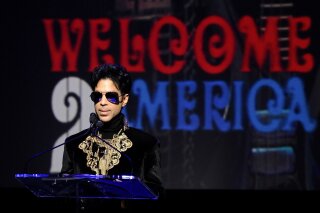 FILE - In this Oct. 14, 2010 file photo, musician Prince holds a news conference at The Apollo Theater announcing his "Welcome 2 America" tour in New York. The ongoing controversy over the money left behind by Prince when he died without a will is heating up again after Internal Revenue Service calculations showed that executors of the rock star's estate undervalued it by 50%, or about $80 million. (AP Photo/Peter Kramer, File)