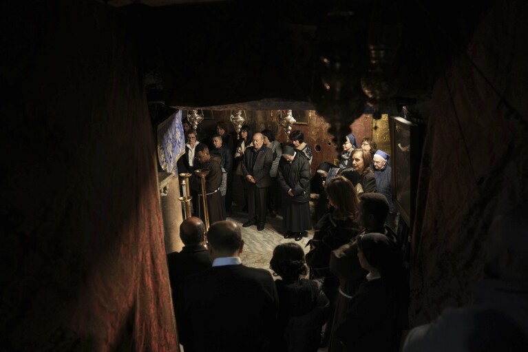 Christian worshipers pray at the Grotto, under the Church of the Nativity, traditionally believed to be the birthplace of Jesus, on Christmas Day, in the West Bank city of Bethlehem, Monday, Dec. 25, 2023. Bethlehem is having a subdued Christmas after officials in Jesus' traditional birthplace decided to forgo celebrations due to the Israel-Hamas war. (AP Photo/Mahmoud Illean)