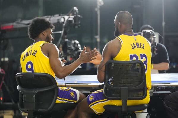 Los Angeles Lakers' LeBron James, right, and his son, Bronny James Jr, shake hands after an interview during the NBA basketball team's media day in El Segundo, Calif., Monday, Sept. 30, 2024. (AP Photo/Jae C. Hong)