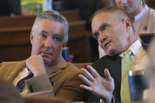 Kansas state Reps. Gary White, left, R-Ashland, confers with Rep. Shannon Francis, R-Liberal, confer as the House votes on legislation, Wednesday, March 27, 2024, at the Statehouse in Topeka, Kan. The two lawmakers support a measure approved by the House to limit ownership of land by people and companies from China and other U.S. adversaries. (AP Photo/John Hanna)