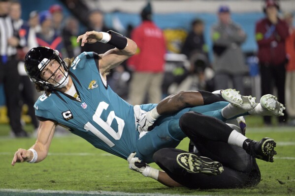 Jacksonville Jaguars quarterback Trevor Lawrence (16) is brought down by Baltimore Ravens defensive tackle Justin Madubuike after Lawrence tried to pass in the second half of an NFL football game Sunday, Dec. 17, 2023, in Jacksonville, Fla. (AP Photo/Phelan M. Ebenhack)