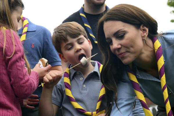 Britain's Prince Louis eats toasted marshmallows as they take part in the Big Help Out, during a visit to the 3rd Upton Scouts Hut in Slough, England, Monday, May 8, 2023. People across Britain were on Monday asked to do their duty as the celebrations for King Charles III's coronation drew to a close with a massive volunteering drive. (Daniel Leal/Pool Photo via AP)
