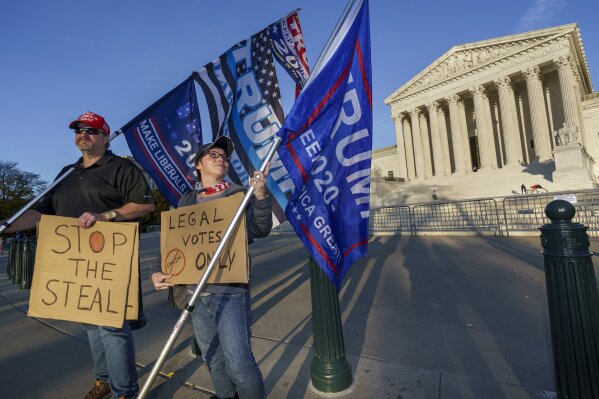 While waiting for a result in the election, Scott Knuth of Woodbridge, Va., left, and Christy Pheagin, of Washington, stand outside the Supreme Court in support of President Donald Trump as they engage in political discussions with people passing by, in Washington, Friday afternoon, Nov. 6, 2020. (AP Photo/J. Scott Applewhite)
