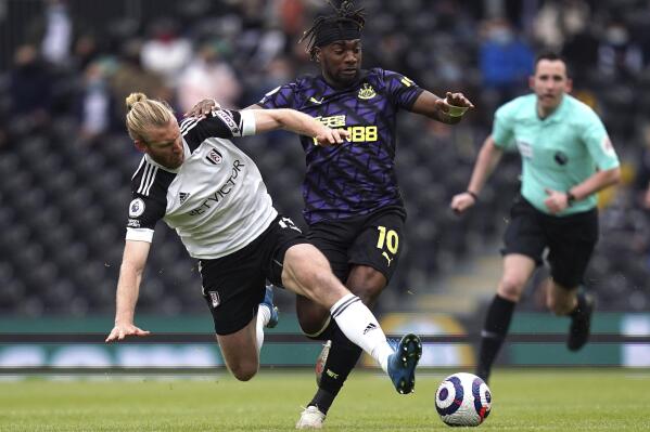 Fulham's Tim Ream, left, and Newcastle United's Allan Saint-Maximin battle for the ball during the English Premier League soccer match at Craven Cottage, London, Sunday May 23, 2021. (Matthew Childs/Pool via AP)