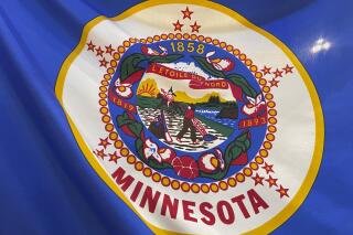 The Minnesota state flag is seen as displayed in the State Capitol building rotunda on Thursday, March 24, 2022, in St. Paul, Minn. Minnesota lawmakers are resurrecting an effort to redesign the state's flag and seal, which proponents say are indistinct compared with other U.S. states and feature imagery that is offensive to Native Americans. (Mohamed Ibrahim/Report for America via AP)