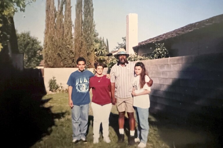 This family photo shows Carl Grant and his partner, Ronda Hernandez, and her children, Michael and Michelle, in a friend's backyard in California in the mid-1990s. (Family Photo via AP)