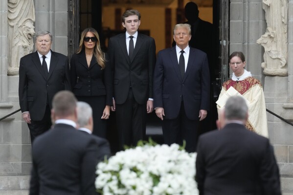 Former President Donald Trump, center right, stands with his wife Melania, second left, their son Barron, center left, and father-in-law Viktor Knavs, as the coffin carrying the remains of Amalija Knavs, the former first lady's mother, is carried into the Church of Bethesda-by-the-Sea for her funeral, Thursday, Jan. 18, 2024, in Palm Beach, Fla. (AP Photo/Rebecca Blackwell)