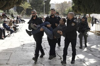 FILE - Israeli police detain a Palestinian in the Al-Aqsa Mosque compound following a raid of the site in the Old City of Jerusalem during the Muslim holy month of Ramadan, Wednesday, April 5, 2023. Israel is holding 1,201 detainees — nearly all of them Palestinians —without charge or trial, the highest number in over three decades, an Israeli human rights group said Tuesday, Aug. 1, 2023. (AP Photo/Mahmoud Illean, File)
