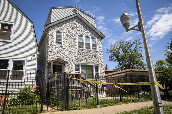 Crime scene tape hangs outside a house where multiple people were shot, some fatally, inside the Englewood building, Tuesday, June 15, 2021. An argument in the house on Chicago's South Side erupted into gunfire early Tuesday. (Ashlee Rezin Garcia/Chicago Sun-Times via AP)