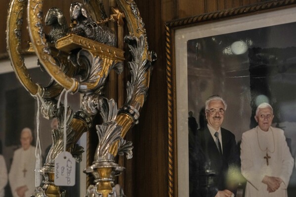A picture of Italian tailor Raniero Mancinelli and late Pope Benedict XVI hangs inside Mancinelli's shop in Rome, Wednesday, April 30, 2025. (AP Photo/Gregorio Borgia)