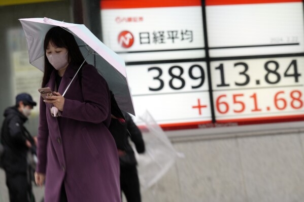 A person walks in front of an electronic stock board showing Japan's Nikkei 225 index at a securities firm Thursday, Feb. 22, 2024, in Tokyo. (AP Photo/Eugene Hoshiko)