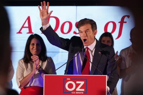 Mehmet Oz, a Republican candidate for U.S. Senate in Pennsylvania, right, waves in front of his wife, Lisa, while speaking at a primary night election gathering in Newtown, Pa., Tuesday, May 17, 2022. (AP Photo/Seth Wenig)