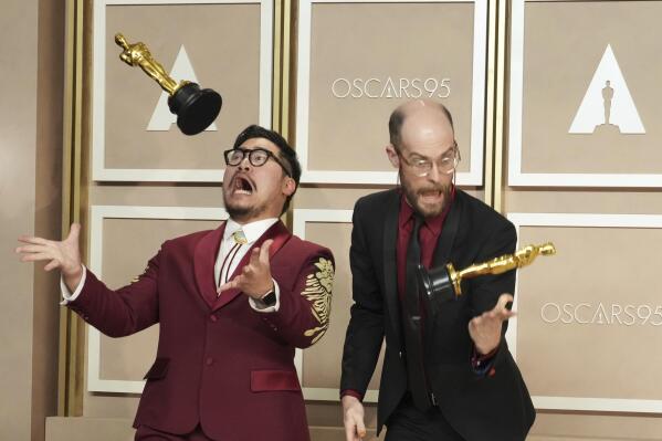 Daniel Kwan, left, and Daniel Scheinert toss their awards for best picture for "Everything Everywhere All at Once" as they pose in the press room at the Oscars on Sunday, March 12, 2023, at the Dolby Theatre in Los Angeles. (Photo by Jordan Strauss/Invision/AP)