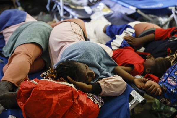 Migrants sleep outside on Lampedusa Island, Italy, Thursday, Sept. 14, 2023. A migrant reception center in Italy’s southernmost island of Lampedusa was overwhelmed Thursday as authorities worked to transfer to the mainland thousands of people who arrived on small, unseaworthy boats in a 24-hour span this week. (Cecilia Fabiano/LaPresse via AP)