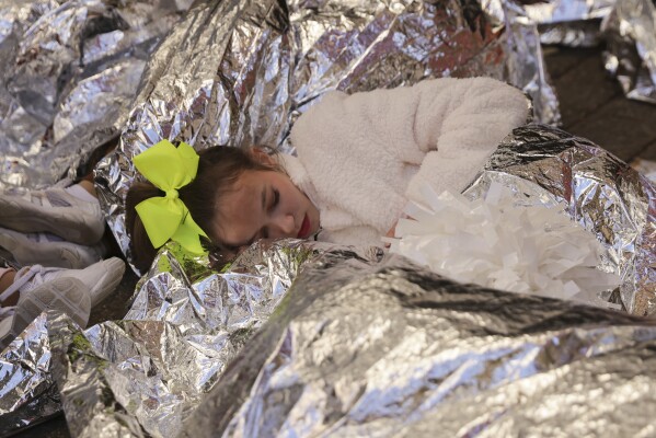 Young performers rest before participating in the Macy's Thanksgiving Day parade, Thursday, Nov. 23, 2023, in New York. (AP Photo/Jeenah Moon)