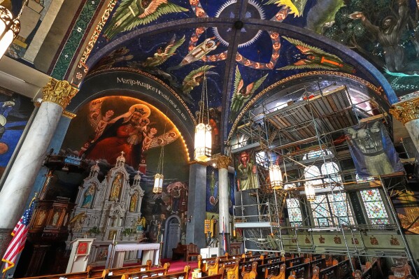 A 32-foot-high scaffold allows art conservation workers close up access to murals by Maxo Vanka on the ceiling in St. Nicholas Croatian Catholic Church as part of an ongoing preservation project in Millvale, Pa., Tuesday, March 18, 2025. (AP Photo/Gene J. Puskar)
