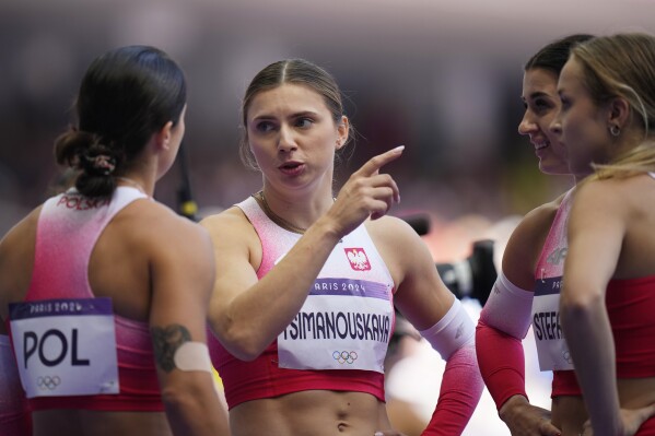 Krystsina Tsimanouskaya, of Poland, gestures as she talks with teammates following their women's 4x100-meter relay heat at the 2024 Summer Olympics, Thursday, Aug. 8, 2024, in Saint-Denis, France. (AP Photo/Petr David Josek)
