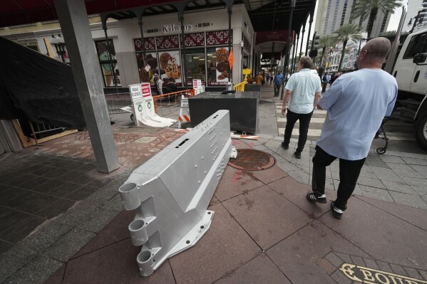 Newly installed security barriers are seen on Bourbon Street next to a memorial for victims of the Jan. 1 car attack ahead of the Super Bowl in New Orleans, Friday, Jan. 31, 2025. (AP Photo/Gerald Herbert)