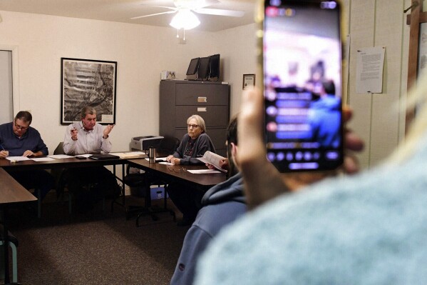 Cheryl Geidner of New Wilmington, Pa., records the Volant Borough Council meeting on her phone Tuesday, Dec. 12, 2023, at the borough building in Volant, Pa. Local governments in many states are making it harder for the public to access information, with residents increasingly complaining about issues like closed meetings and high fees for records, open government advocates and experts say. The result is important business often taking place under a shroud of secrecy. (Tiffany Wolfe/New Castle News via AP)