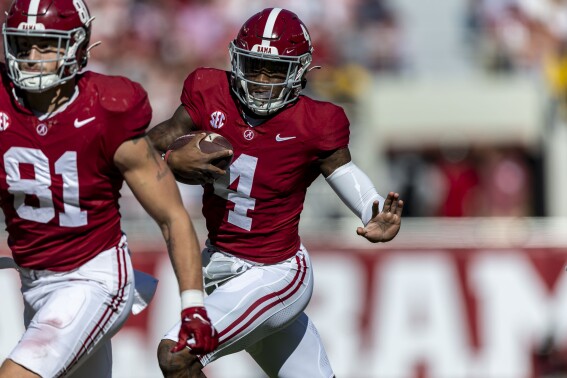 Alabama quarterback Jalen Milroe (4) runs the ball against Chattanooga during the first half of an NCAA college football game, Saturday, Nov. 18, 2023, in Tuscaloosa, Ala. Alabama tight end CJ Dippre (81) is looking to block in the foreground. (AP Photo/Vasha Hunt)