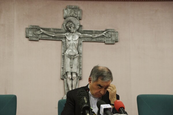 FILE - Cardinal Angelo Becciu talks to journalists during a press conference in Rome, Friday, Sept. 25, 2020. Lawyers for the once-powerful cardinal have accused Vatican prosecutors of being “prisoners to their completely shattered theory" in closing arguments of a two-year trial. Becciu is on trial along with nine other people in a case that is focused on the Vatican’s 350 million-euro investment in a London property. (AP Photo/Gregorio Borgia)