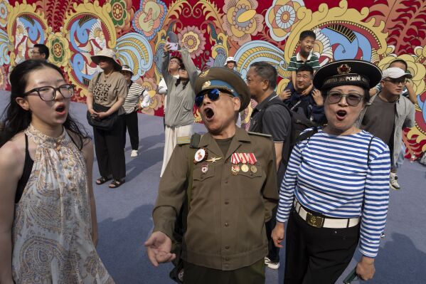 A Chinese veteran wearing an old Soviet style military uniform sings during an event promoting tourism to Moscow at the Wangfujing Shopping Street in Beijing, China, Thursday, June 12, 2025. (AP Photo/Ng Han Guan)