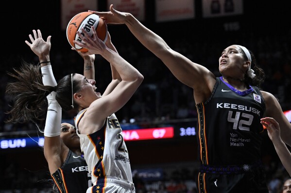 Connecticut Sun forward Brionna Jones (42) blocks a shot by Indiana Fever guard Caitlin Clark ( 22) in the second half of a WNBA basketball game, Tuesday, May 14, 2024, in Uncasville, Conn. (AP Photo/Jessica Hill)