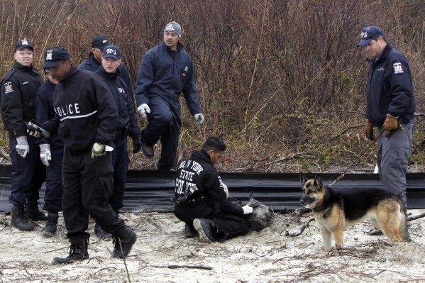 FILE - Law enforcement and emergency personnel examine an object on the side of the road, center, near Jones Beach on April 11, 2011, in Wantagh, N.Y. A Long Island architect has been charged, Friday, July 14, 2023, with murder in the deaths of three of the 11 victims in a long-unsolved string of killings known as the Gilgo Beach murders. (AP Photo/Seth Wenig, File)