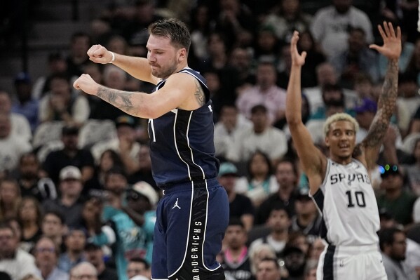 Dallas Mavericks guard Luka Doncic, left, reacts to a score against the San Antonio Spurs during the first half of an NBA basketball game in San Antonio, Wednesday, Oct. 25, 2023. (AP Photo/Eric Gay)