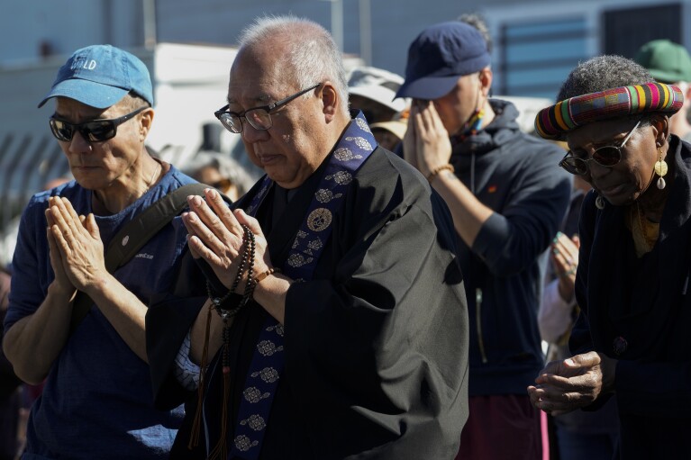 Buddhist faith leaders and community members pray during a "May We Gather" pilgrimage, Saturday, March 16, 2024, in Antioch, Calif. The event aimed to use karmic cleansing through chants, prayer and testimony to heal racial trauma caused by anti-Chinese discrimination in Antioch in the 1870s. (AP Photo/Godofredo A. Vasquez)