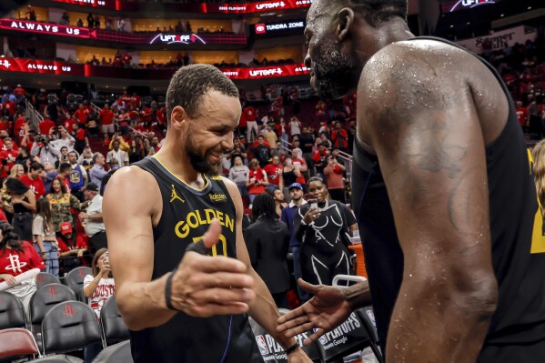 Golden State Warriors' Stephen Curry (30) celebrates with Draymond Green (23) after Game 7 of an NBA basketball first-round playoff series against the Houston Rockets in Houston, Sunday, May 4, 2025. (Carlos Avila Gonzalez/San Francisco Chronicle via AP)