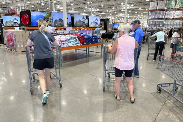 Shoppers push carts into a Costco warehouse Friday, Aug. 4, 2023, in Thornton, Colo. The stickiness of inflation could endanger the possibility that the Fed will achieve a rare 