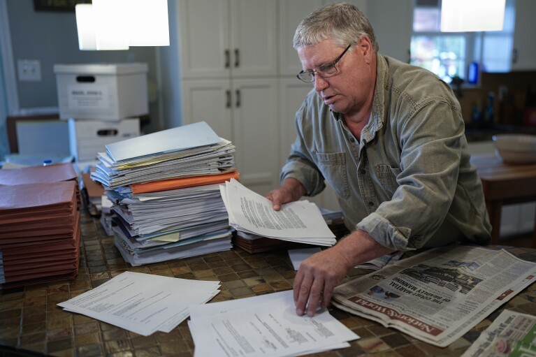 John Maas looks through legal documents Thursday, Sept. 14, 2023, in Sparta, Tenn. Thousands of people who helped clean up after the 2010 BP oil spill in the Gulf of Mexico say they got sick, including Maas. Attorneys familiar with the issue say he's the only one who has received a settlement after suing. (AP Photo/George Walker IV)