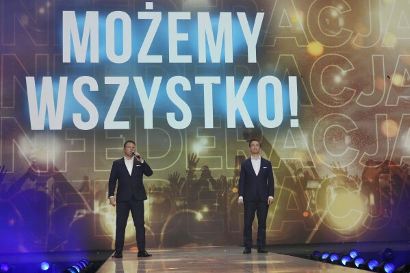 Slawomir Mentzen, left, and Krzysztof Bosak, right, the oo-leders of the hard right Confederation party, present their party slogan "Mozemy Wszystko!" (We Can Do Anything) at a convention in Katowice, Poland, on Saturday, Sept. 23, 2023. Confederation has been growing in popularity, especially among young men. The party has been riding a wave of growing support for far-right parties across Europe, and polls show it could increase its presence in parliament in a national election Oct. 15. No matter how they do on election day, the party has already done a lot to push the government to take a more confrontational stance to Ukraine, which is fighting for its survival against Russia. (AP Photo/Czarek Sokolowski)