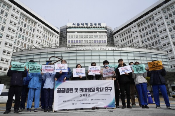 Μέλη της Κορεατικής Ένωσης Εργαζομένων Δημοσίων Υπηρεσιών και Μεταφορών πραγματοποιούν πορεία για να απαιτήσουν την επέκταση των δημόσιων νοσοκομείων και των φοιτητών ιατρικής στο Εθνικό Πανεπιστημιακό Νοσοκομείο της Σεούλ στη Σεούλ, Νότια Κορέα, Τρίτη 27 Φεβρουαρίου 2024. Η πινακίδα λέει "Επέκταση δημόσιων νοσοκομείων και φοιτητών ιατρικής." (AP Photo/Ahn Young Joon)