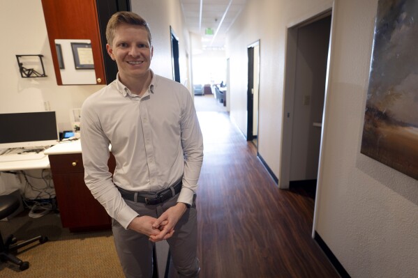 Optometrist Hunter Morgan poses in his offices on Friday, March 1, 2024, in Encinitas, Calif. When Morgan bought an optometry practice in San Diego three years ago, one of the first things he did was start accepting patients who were enrolled in Medicaid — the government-funded health insurance program for the poor and the disabled. Just five months later, Morgan said, he had to stop treating Medicaid patients because of the paltry pay. He charges $175 for eye exams, but the most he could get from Medicaid was about $40. (AP Photo/Gregory Bull)