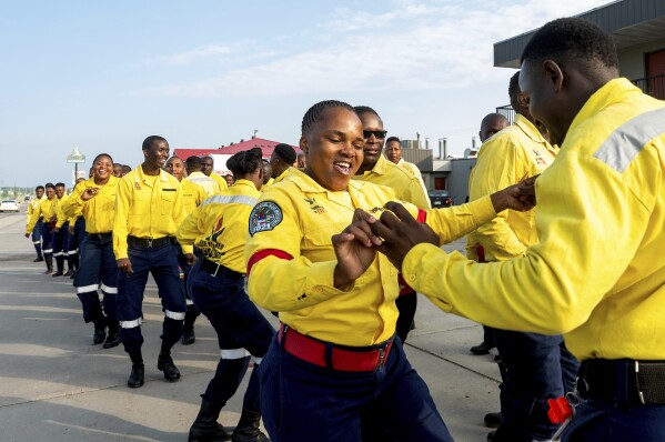 South African firefighters dance during a break in their morning meeting in Fox Creek, Alberta, on Tuesday, July 4, 2023. Several countries, including South Africa, deployed firefighters to Canada to help local efforts to control widespread wildfires. (AP Photo/Noah Berger)