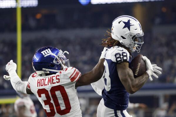 Dallas Cowboys wide receiver CeeDee Lamb (88) catches a pass for a first down as New York Giants cornerback Darnay Holmes (30) defends during the second half of an NFL football game Thursday, Nov. 24, 2022, in Arlington, Texas. (AP Photo/Ron Jenkins)