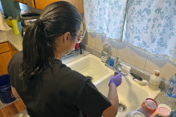 Purdue University graduate student Paula Coelho collects drinking water samples at a home in Kula, Hawaii, on Aug. 20, 2023. A team from Purdue helped the University of Hawaii at Mānoa conduct free sampling in peoples' homes who were issued an "unsafe water alert" as part of a community water sampling program. (Andrew Whelton/Purdue University via AP)
