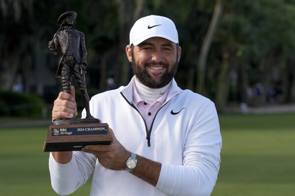 Scottie Scheffler holds the trophy after winning the weather delayed RBC Heritage golf tournament, Monday, April 22, 2024, in Hilton Head Island, S.C. (Ǻ Photo/Chris Carlson)