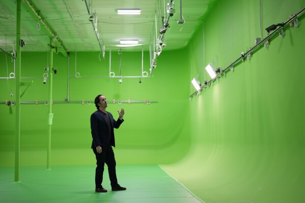 Rob Huberty, Chief Operating Officer and Co-Founder of ZeroEyes, talks about the use of artificial intelligence with surveillance cameras to identify visible guns at the company's greenscreen lab, Friday, May 10, 2024, in Conshohocken, Pa. (AP Photo/Matt Slocum)