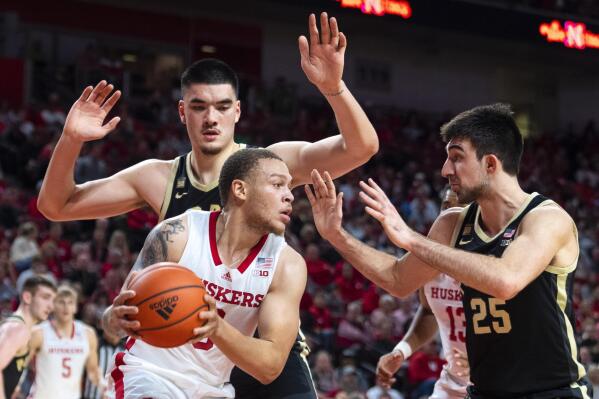 Nebraska's C.J. Wilcher is guarded by Purdue's Zach Edey, top left, and Ethan Morton during the first half of an NCAA college basketball game, Saturday, Dec. 10, 2022, at Pinnacle Bank Arena in Lincoln, Neb. (Kenneth Ferriera/Lincoln Journal Star via AP)
