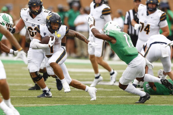 California running back Jaydn Ott (1) looks for room against North Texas safety Patrick Smith (11) during the first half of an NCAA college football game Saturday, Sept. 2, 2023, in Denton, Texas. (AP Photo/Brandon Wade)