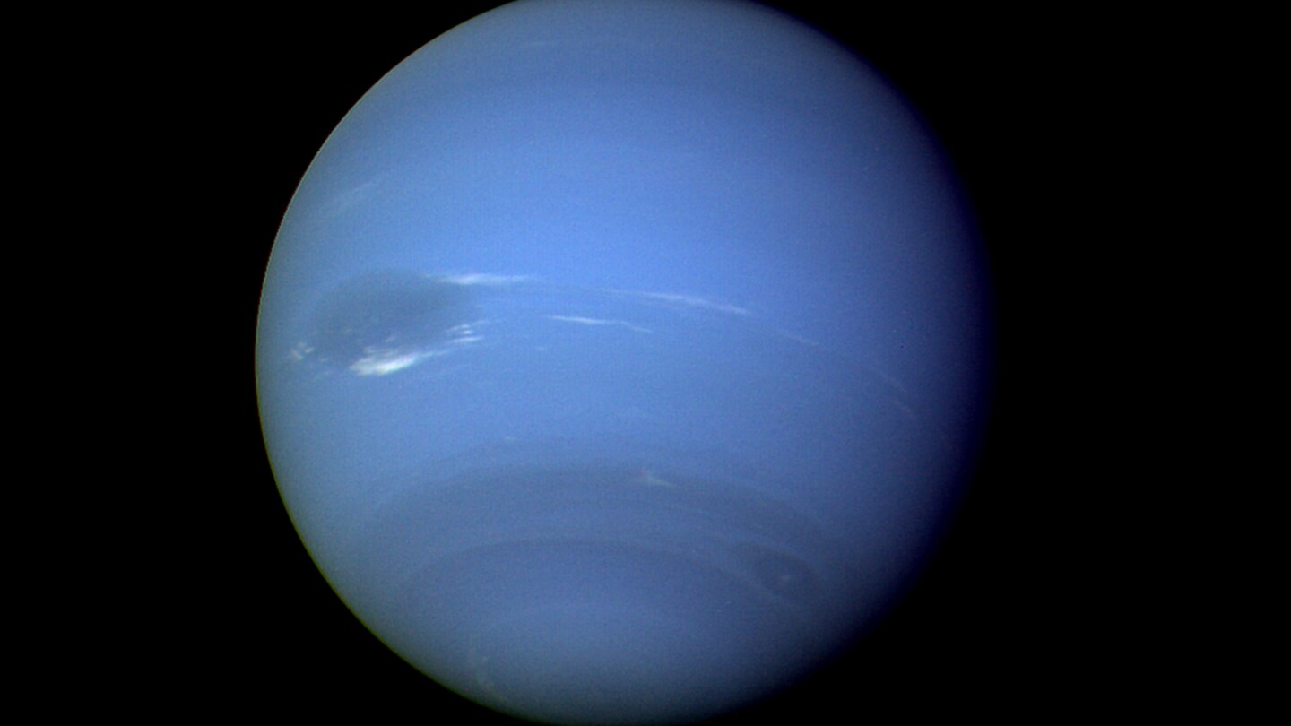 This August 1989 image provided by NASA shows the planet Neptune photographed by the Voyager 2 spacecraft, processed to enhance the visibility of small features. The International Astronomical Union's Minor Planet Center announced Friday , Feb. 23, 2024, that astronomers have found three previously unknown moons in our solar system — two additional moons circling Neptune and one around Uranus. (NASA via AP)