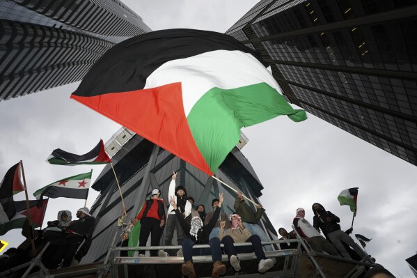 File - Supporters wave the Palestinian flag at a march in Toronto, on Oct. 9, 2023. Before it transformed into X, Twitter was the place to turn to for live and reliable information about big news events, from wars to natural disasters. But as the Israel-Hamas war has underscored, that is no longer the case. (Arlyn McAdorey/The Canadian Press via AP, File)