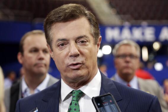 FILE - In this July 17, 2016 file photo, then-Donald Trump campaign chairman Paul Manafort talks to reporters on the floor of the Republican National Convention, in Cleveland. The Justice Department filed a lawsuit Thursday, April 28, 2022 against Donald Trump's former campaign chairman Paul Manafort — who was convicted in special counsel Robert Mueller’s Russia investigation and later pardoned — seeking to recover nearly $3 million from undeclared foreign bank accounts. (AP Photo/Matt Rourke, File)