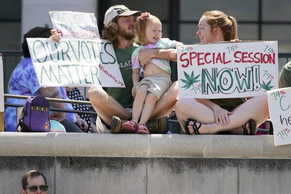 FILE - In this Tuesday, May 25, 2021 file photo, The Norvell family of Flora, Miss., from right, Seleigh Norvell, Ophelia, Norvell, 2, and Ethan Norvell, listen to speakers protesting the Mississippi Supreme Court ruling that invalidated Mississippi's initiative process and overturned a medical marijuana initiative that voters approved in November 2020, at a rally in Jackson, Miss. Mississippi House and Senate negotiators said Thursday, Sept. 23, 2021 that they have agreed on a proposed medical marijuana program. Leaders are expected to ask Republican Gov. Tate Reeves to call the Legislature into session to put the plan into law.. (AP Photo/Rogelio V. Solis, File)