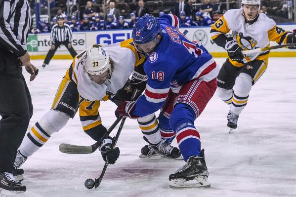 Pittsburgh Penguins center Jeff Carter (77) and New York Rangers center Andrew Copp (18) vie for the puck on a faceoff during the first period of an NHL hockey game Thursday, April 7, 2022, in New York. (AP Photo/Bebeto Matthews)